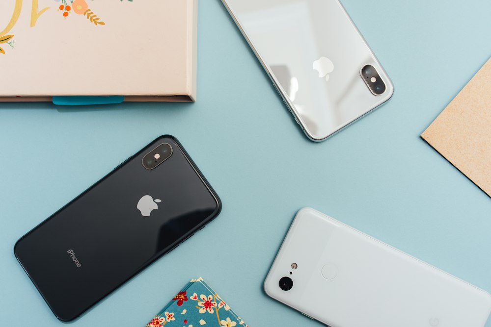 Celulares y accesorios acomodados sobre una mesa celeste