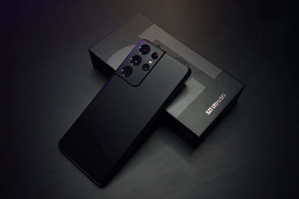 Dos celulares oscuros sobre una superficie negra