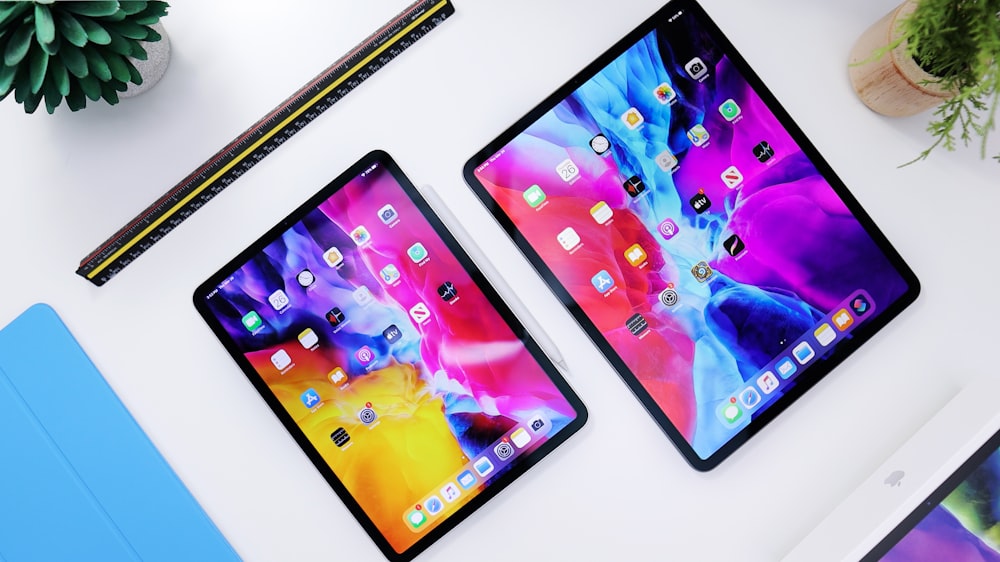 Dos tablets encendidas junto a una laptop
