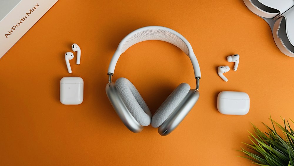 Audífonos y auriculares inalámbricos sobre fondo naranja